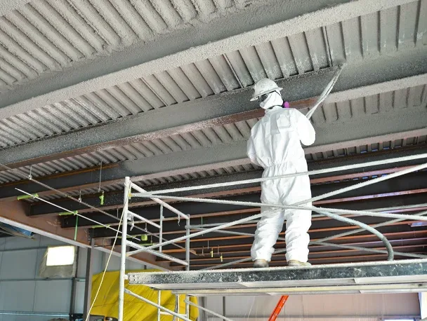 Operario aplicando mortero ignífugo sobre estructura metálica en una obra de Tarragona